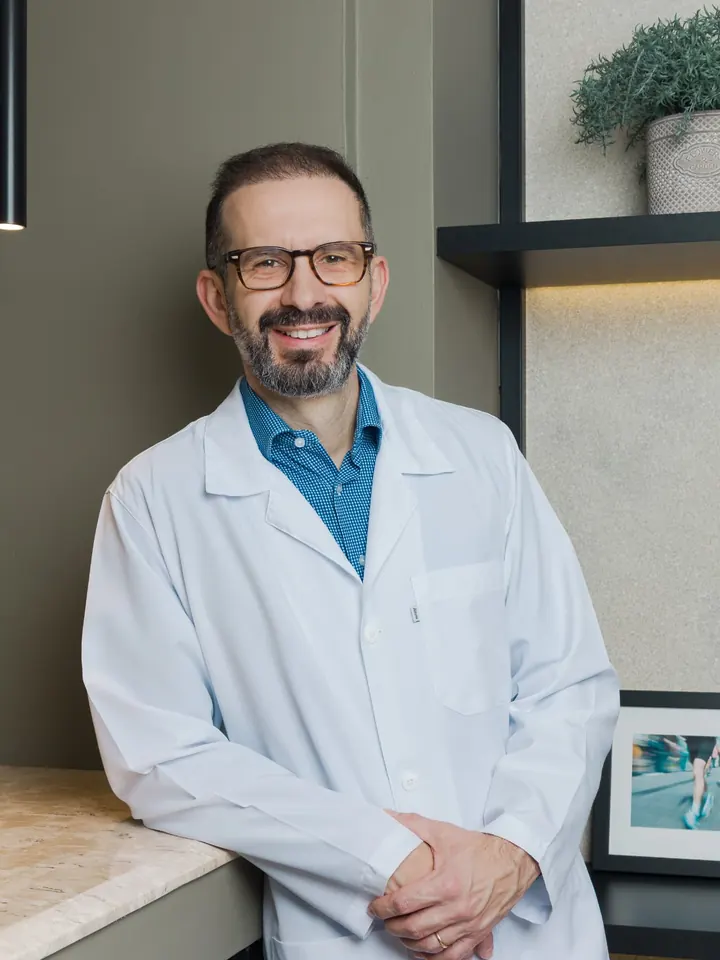 Dr. Marcos Sardinha, cardiologista, de jaleco branco no consultório em Maringá-PR
